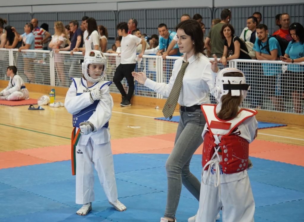 dos competidores de taekwondo combate wtf con el arbitro femenina a punto de empezar la pelea en un campeonato